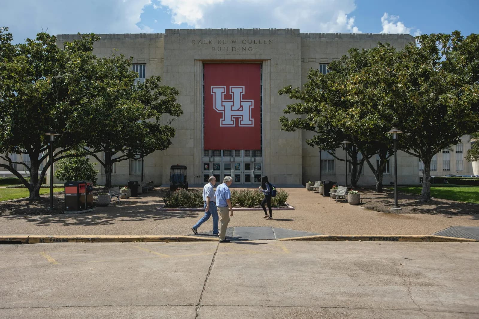People walking outside a building on the University of Houston campus