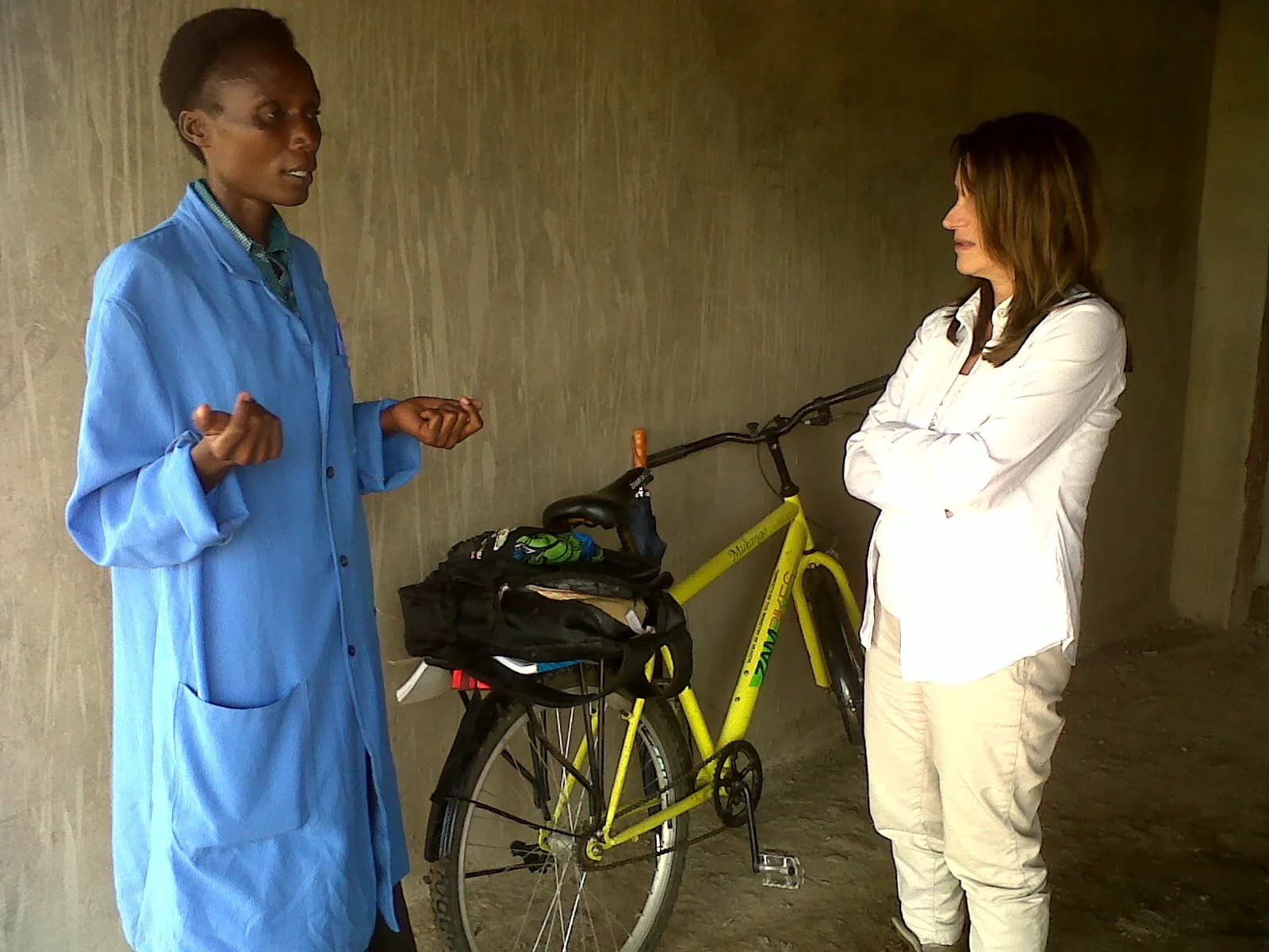 A community health assistant meets UK International Development Minister Lynne Featherstone beside the assistant’s bicycle in Zambia.