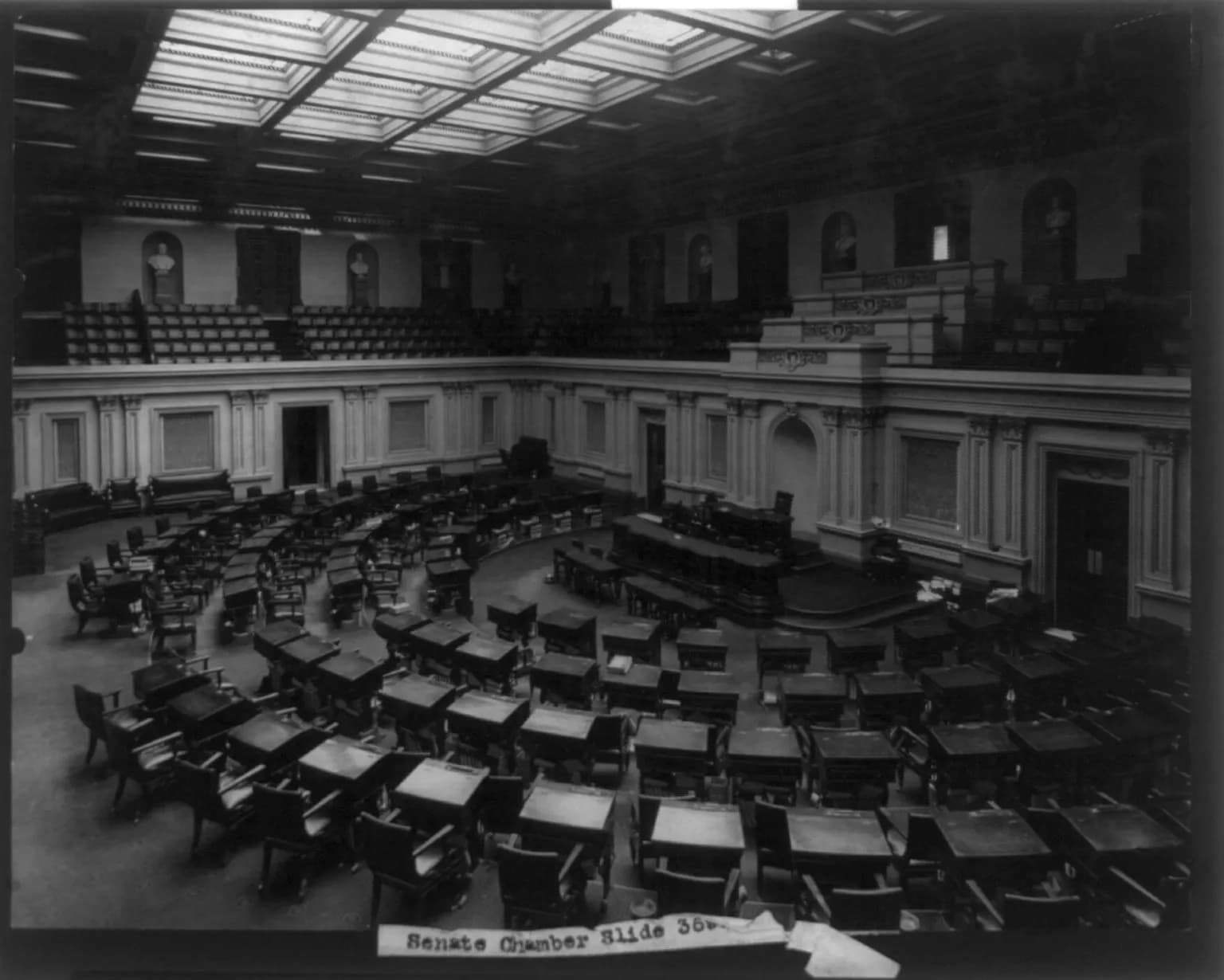A historical interior view of the U.S. Senate chamber, with desks arranged across the chamber floor.