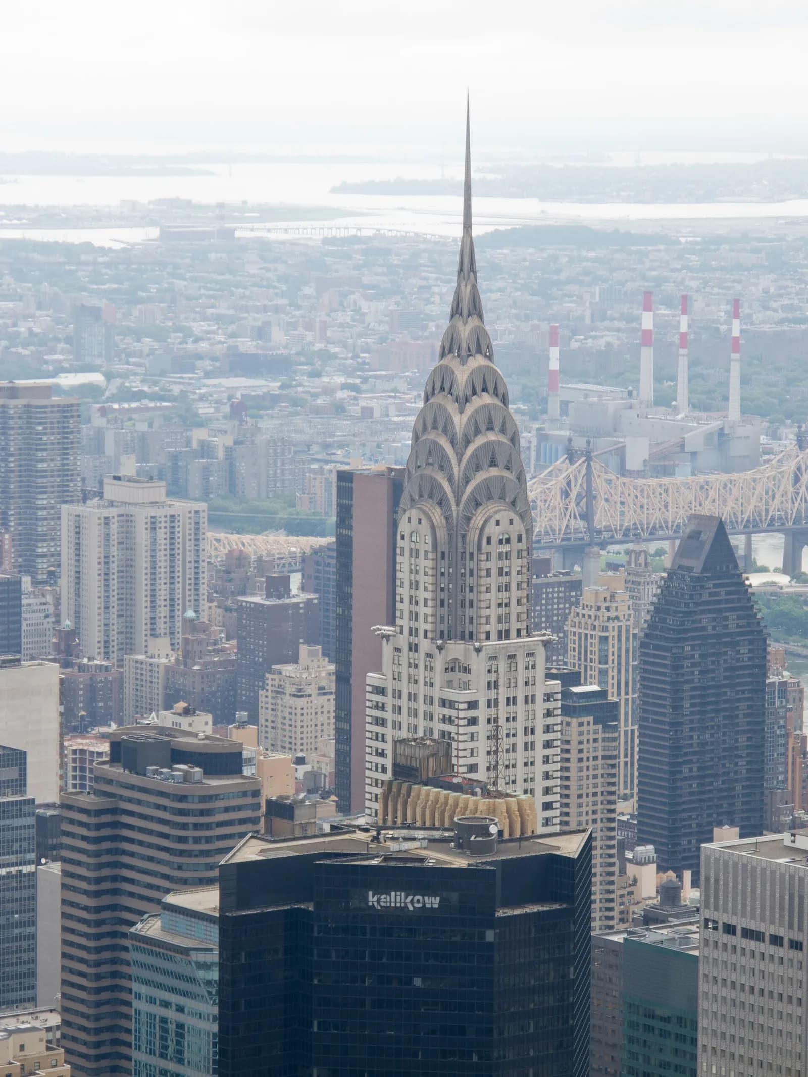 The Chrysler Building rises above the Manhattan skyline, seen from an elevated vantage point.