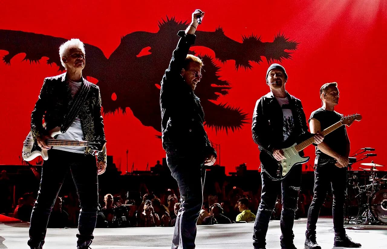 U2 standing together on a concert stage in Kansas City in 2017