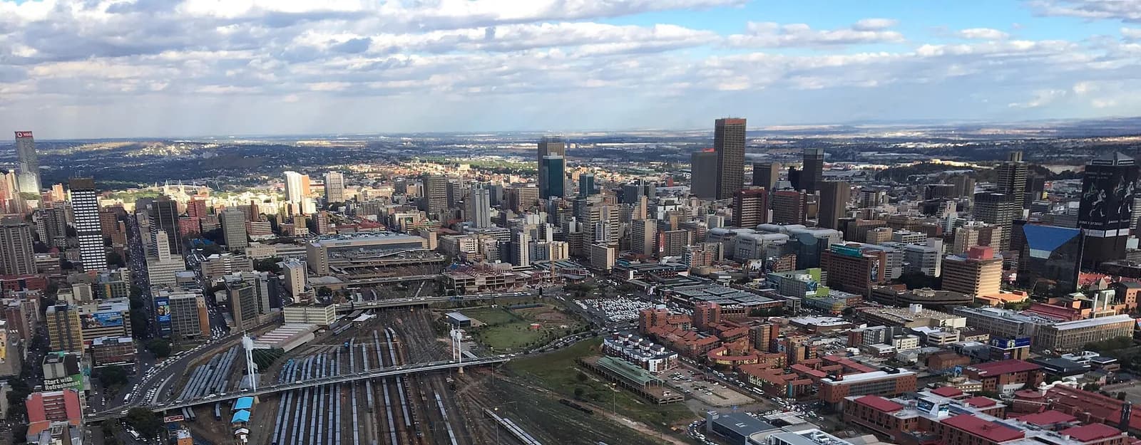 Aerial view across Johannesburg’s skyline, with railway tracks in the foreground.
