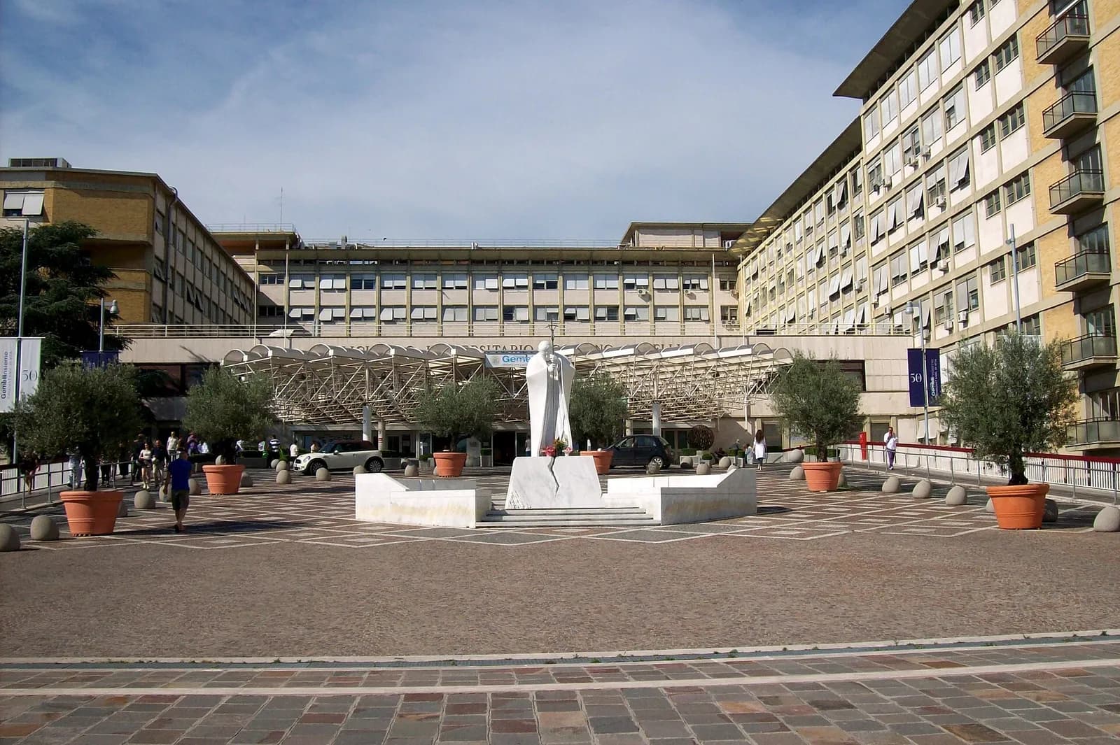 The entrance to Agostino Gemelli University Hospital in Rome, with a statue of Pope John Paul II in front.