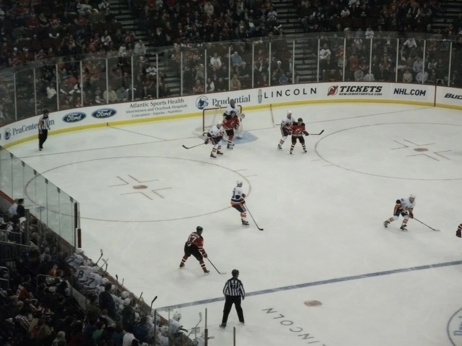 New Jersey Devils and New York Islanders players on the ice at Prudential Center.