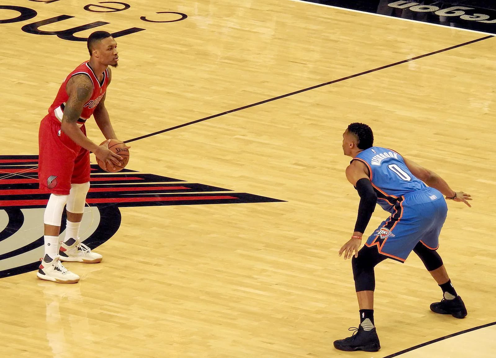 Damian Lillard of the Portland Trail Blazers handles the ball as Russell Westbrook of the Oklahoma City Thunder defends.