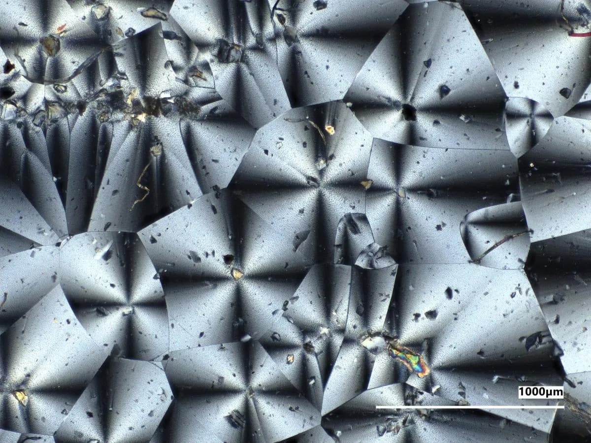 Microscope photograph of a gray NASA-made material sample containing simulated Moon dust