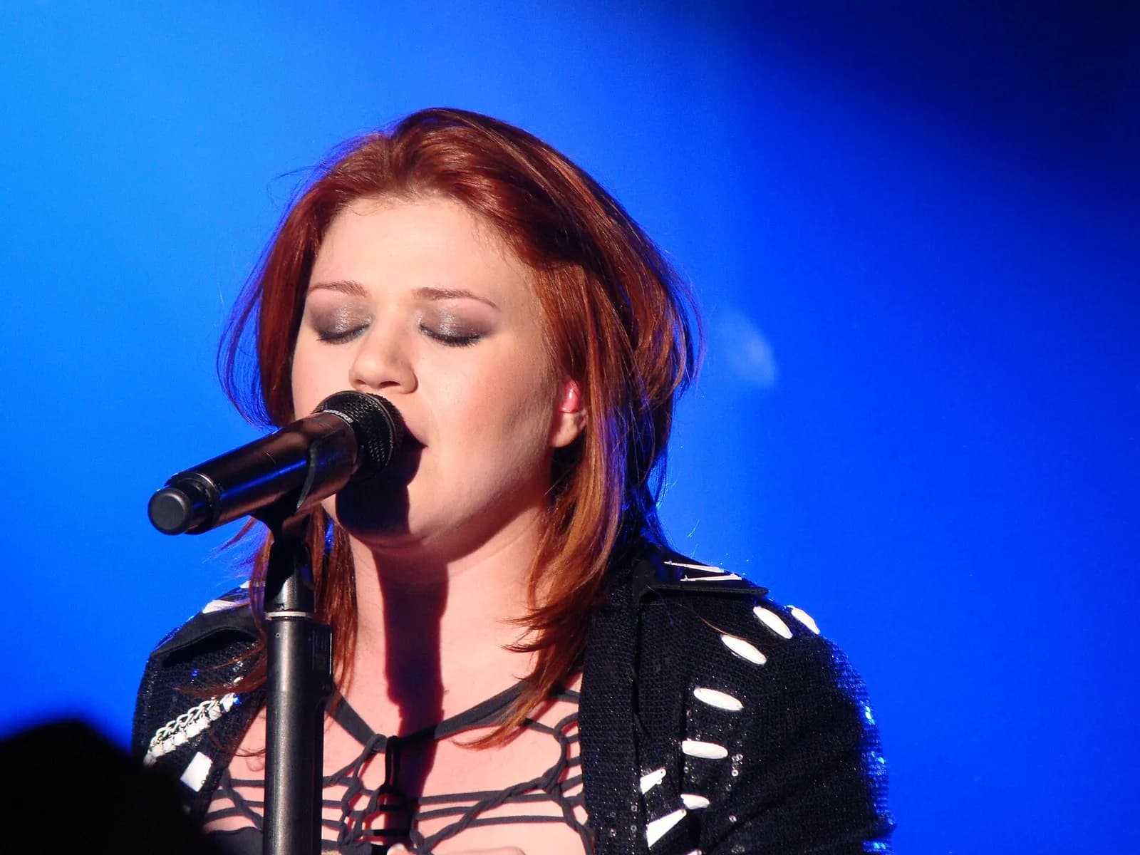 Kelly Clarkson performing on stage in Birmingham, England.