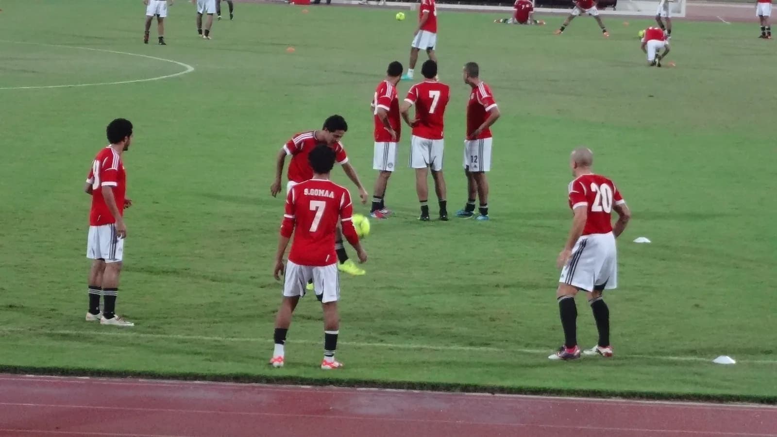 Egyptian players in red shirts and white shorts on a football pitch in Abu Dhabi.