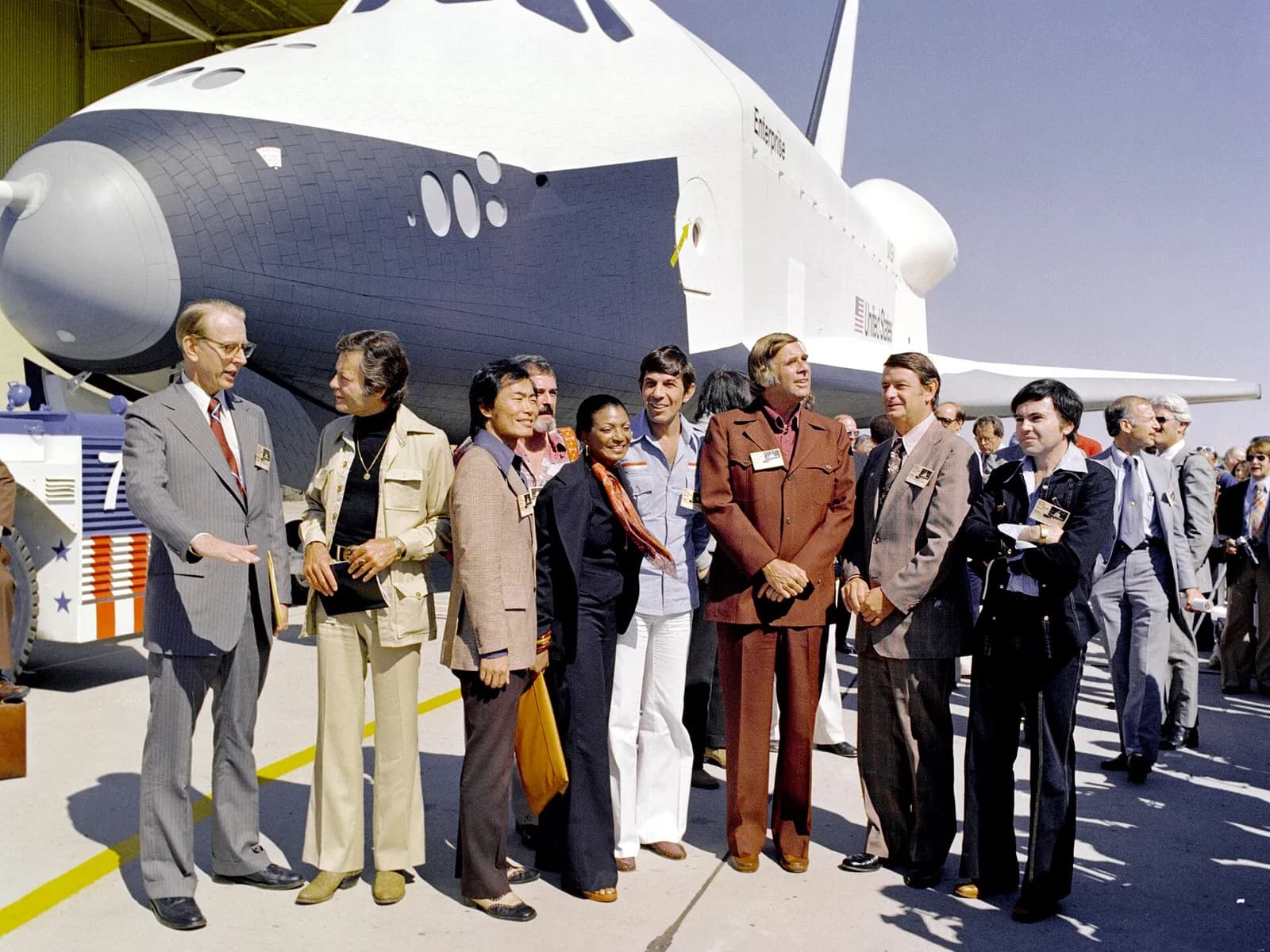 Walter Koenig and other Star Trek cast members stand beside the Space Shuttle Enterprise during its rollout.