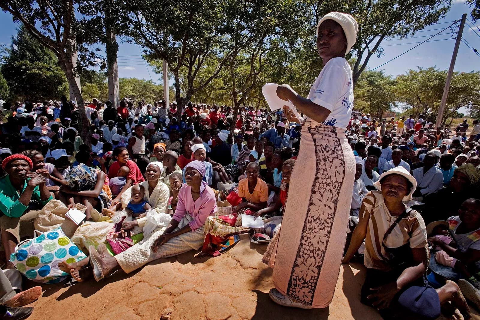 A community worker speaks with women waiting to collect food rations at a distribution point in Epworth, Harare, Zimbabwe.