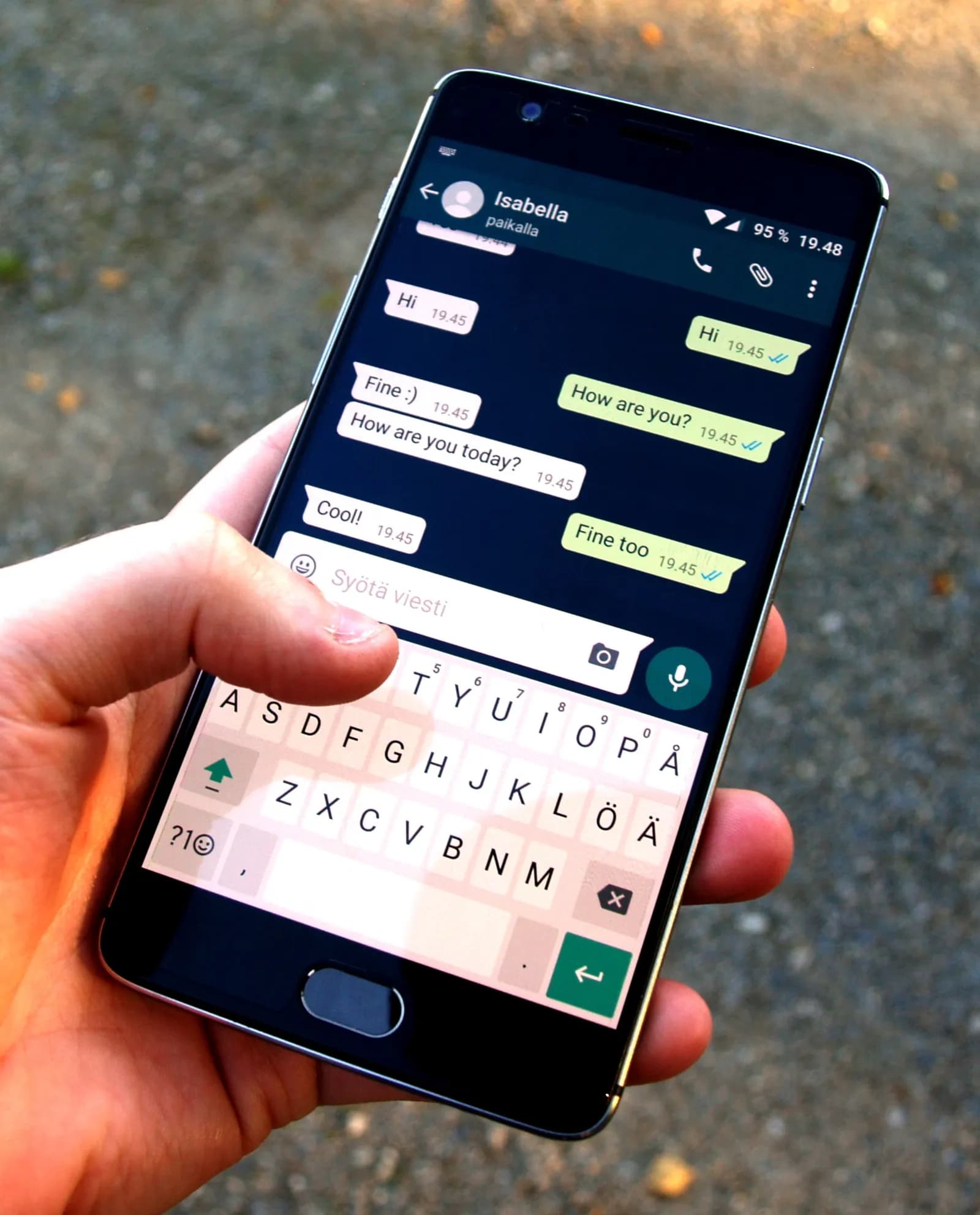 A person holding a smartphone and using WhatsApp
