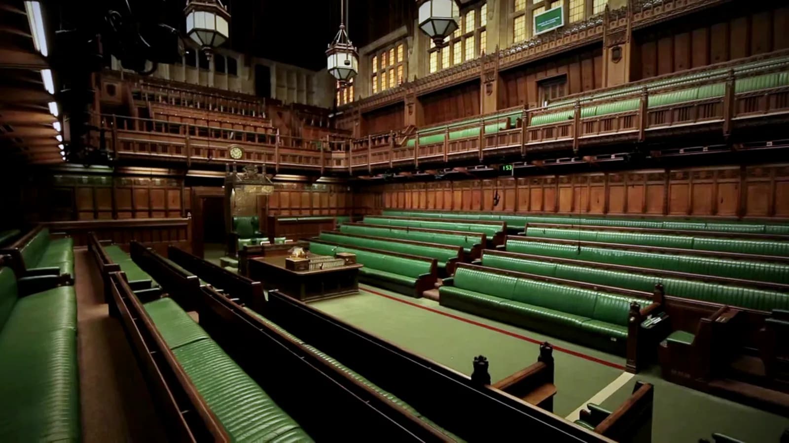 The green benches and central table in the House of Commons chamber in London.