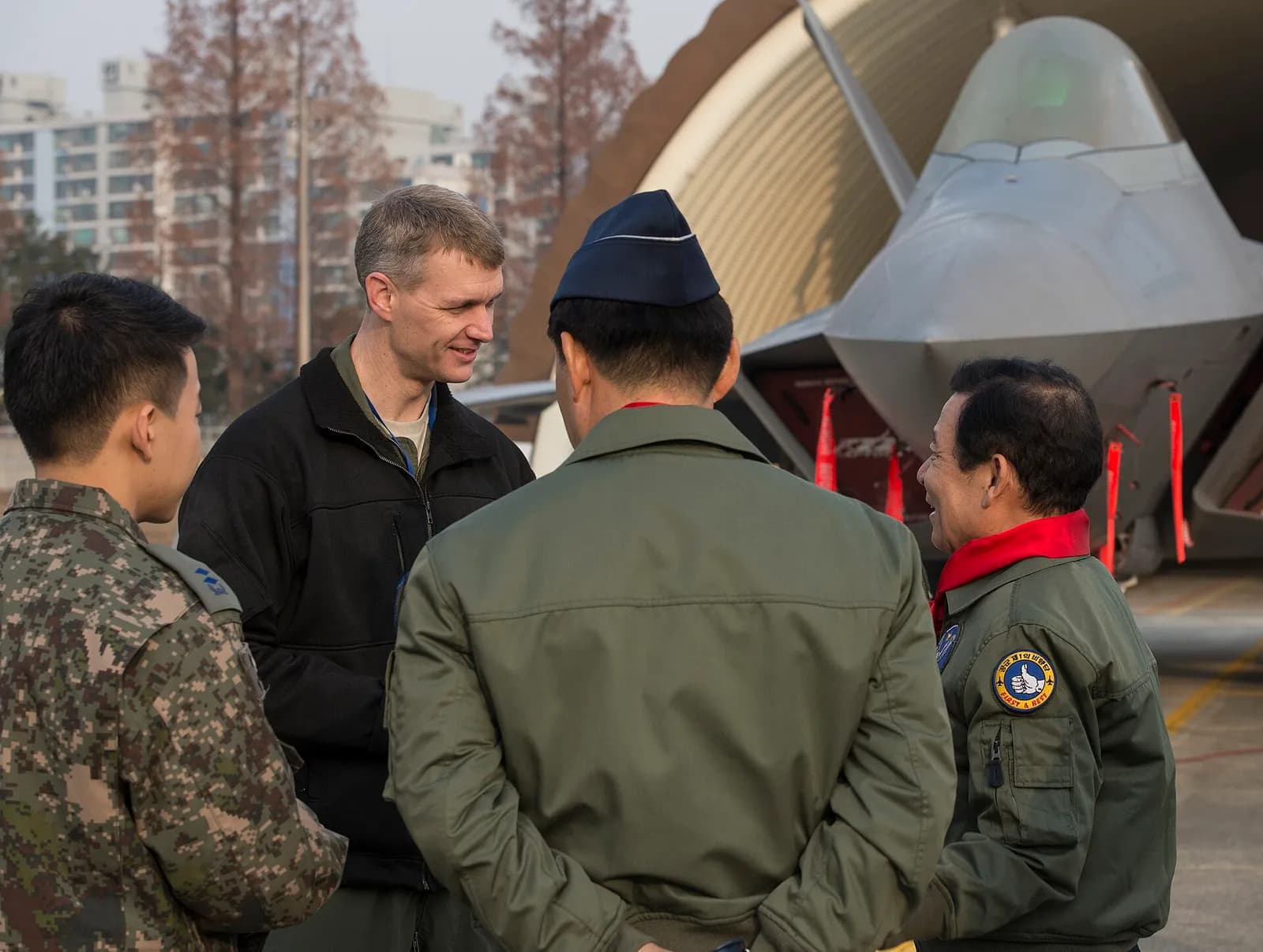 Gwangju Mayor Jang Hyun Yoon speaks with U.S. and South Korean air force members beside an F-22 at Gwangju Air Base.