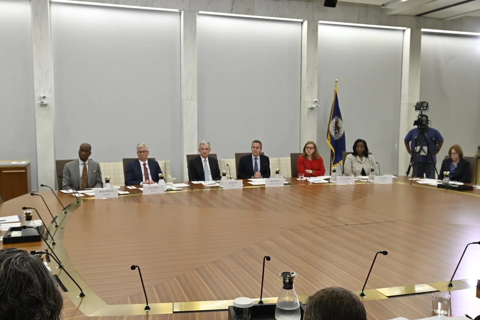 Federal Reserve Board members seated around a table during an open meeting.