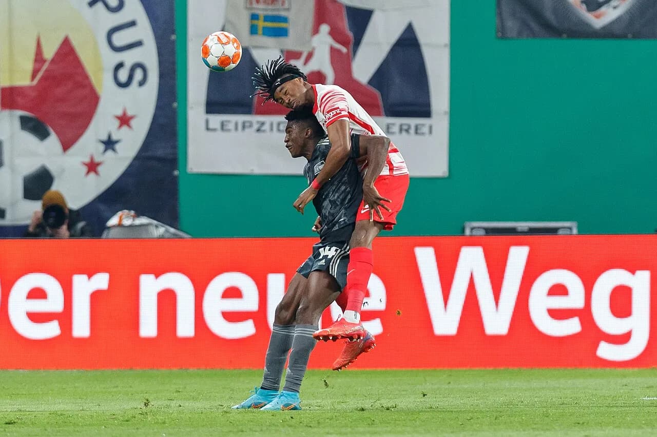 Taiwo Awoniyi of Union Berlin challenges Mohamed Simakan of RB Leipzig during a football match.