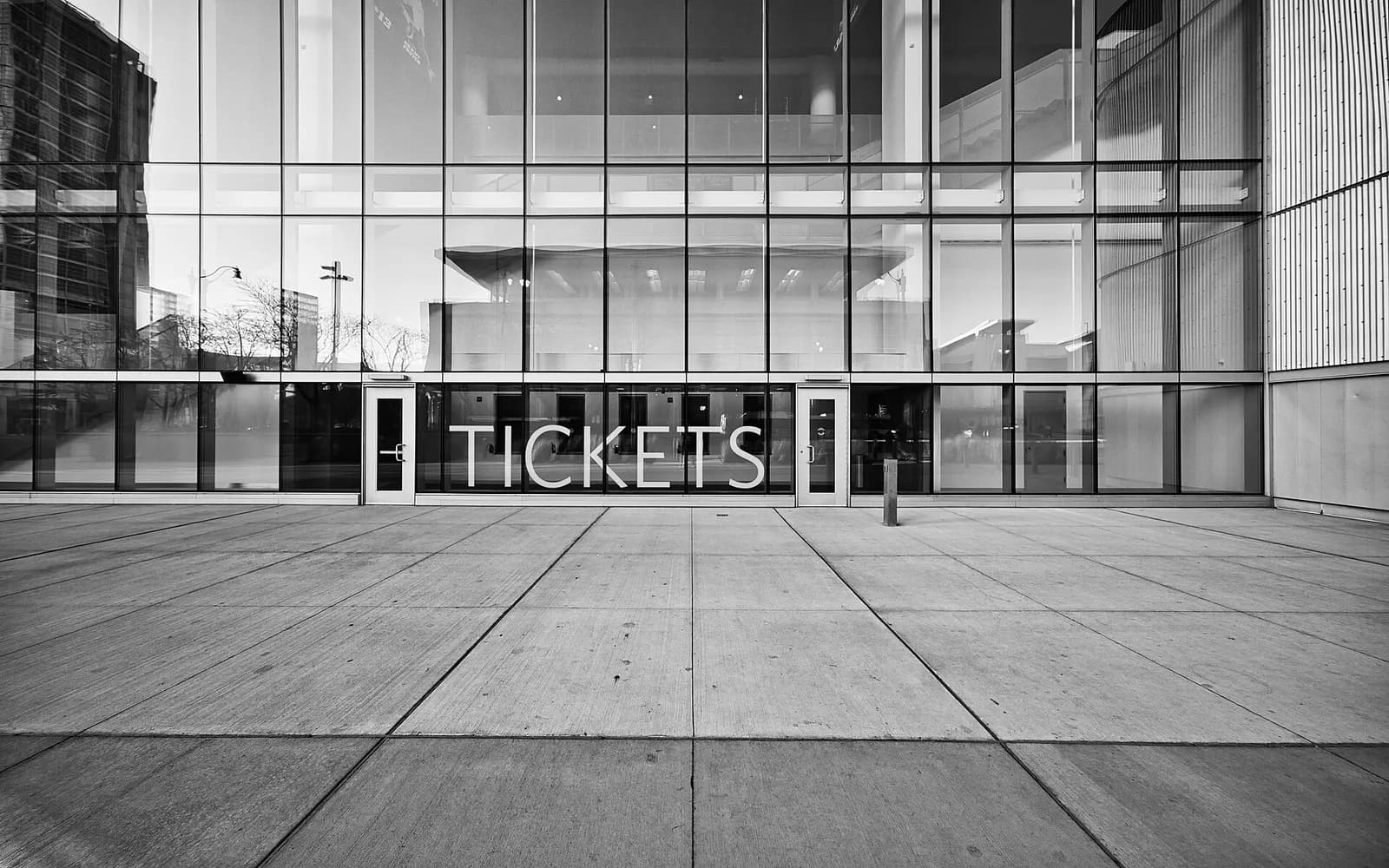 Glass facade of Wintrust Arena beside a tickets sign.