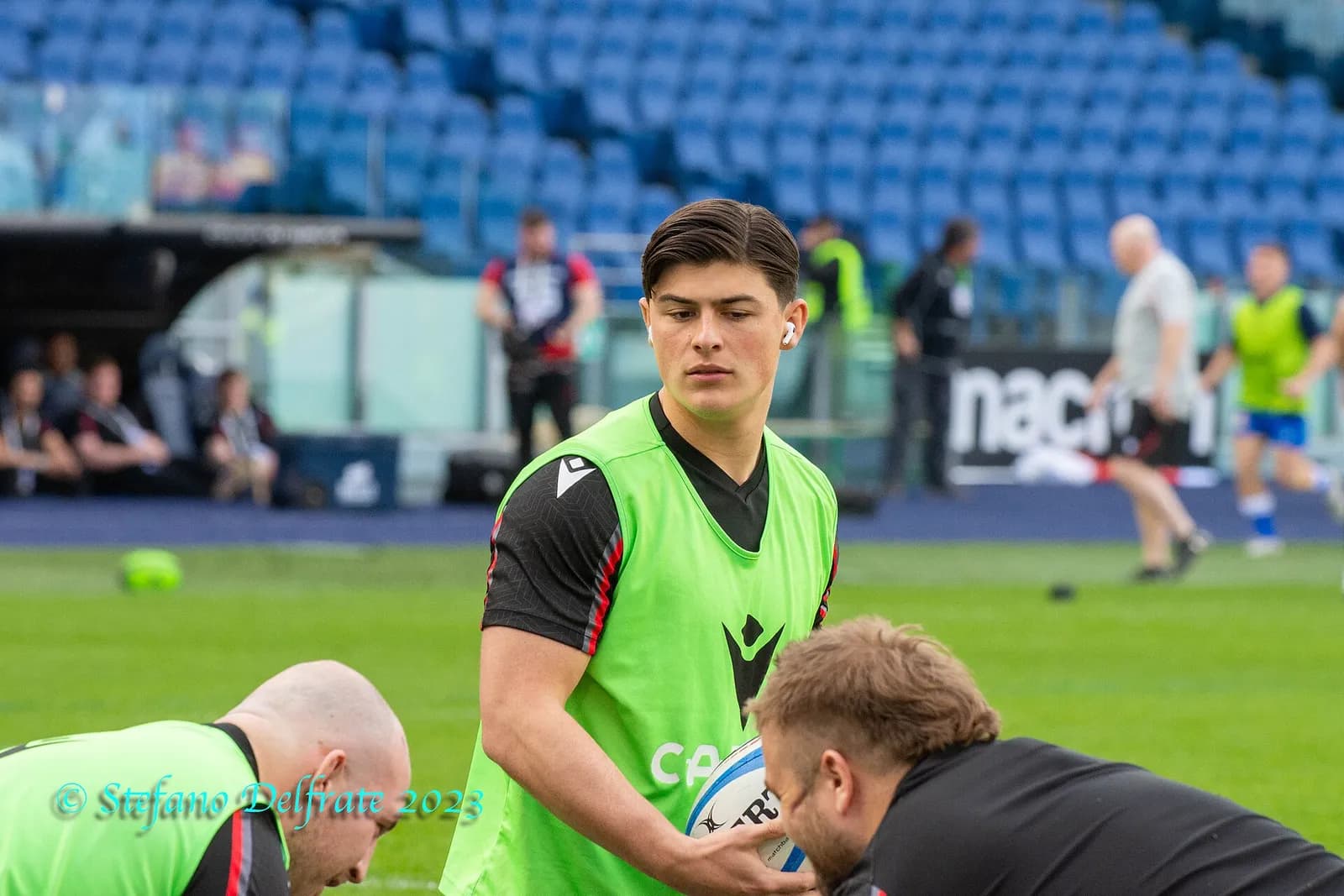 Louis Rees-Zammit holding a rugby ball and wearing a training bib at the 2023 Italy–Wales Six Nations fixture.