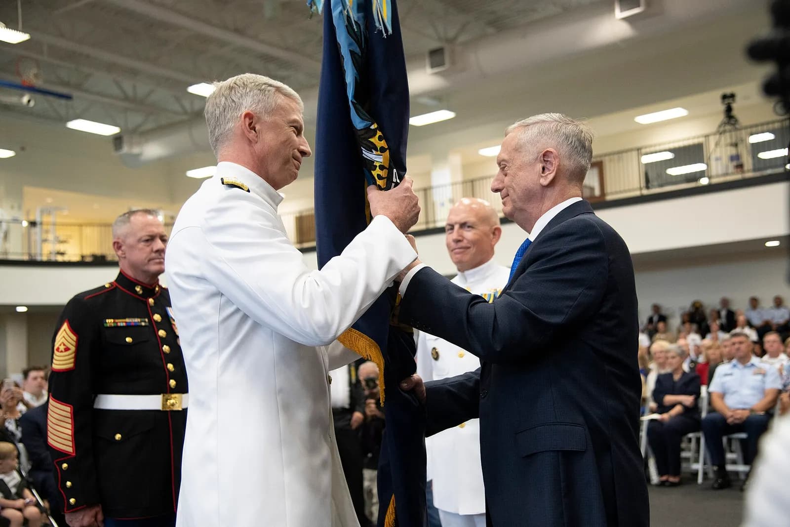 Defense Secretary James Mattis passes the SOUTHCOM guidon to incoming commander Craig Faller during a ceremony at the command's headquarters.