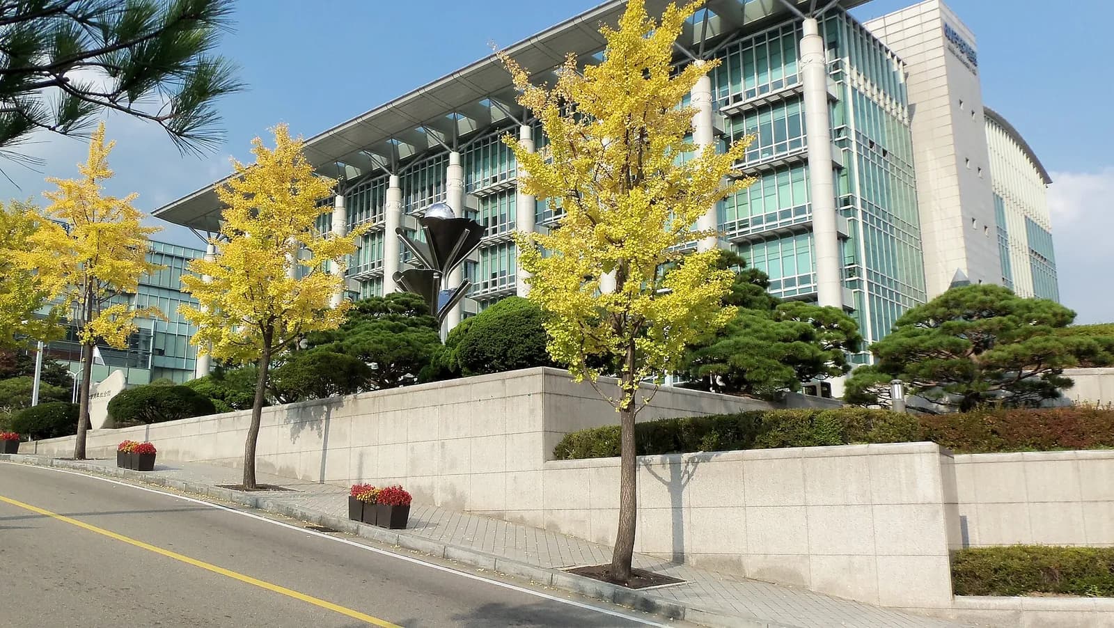 The 600 Anniversary Hall at Sungkyunkwan University in Seoul, framed by autumn trees.