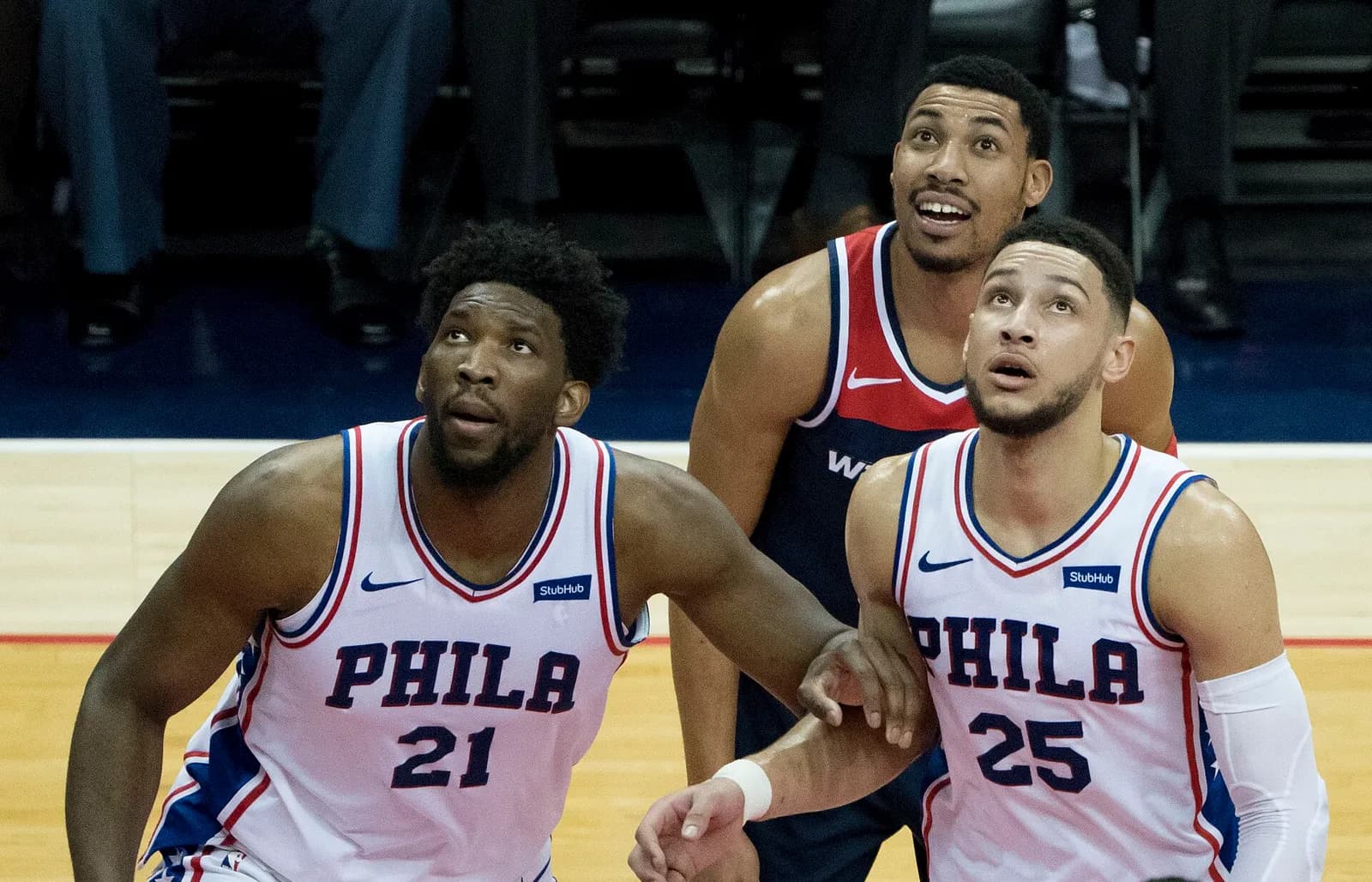 Joel Embiid and Ben Simmons of the Philadelphia 76ers position for a rebound during a game against the Washington Wizards.
