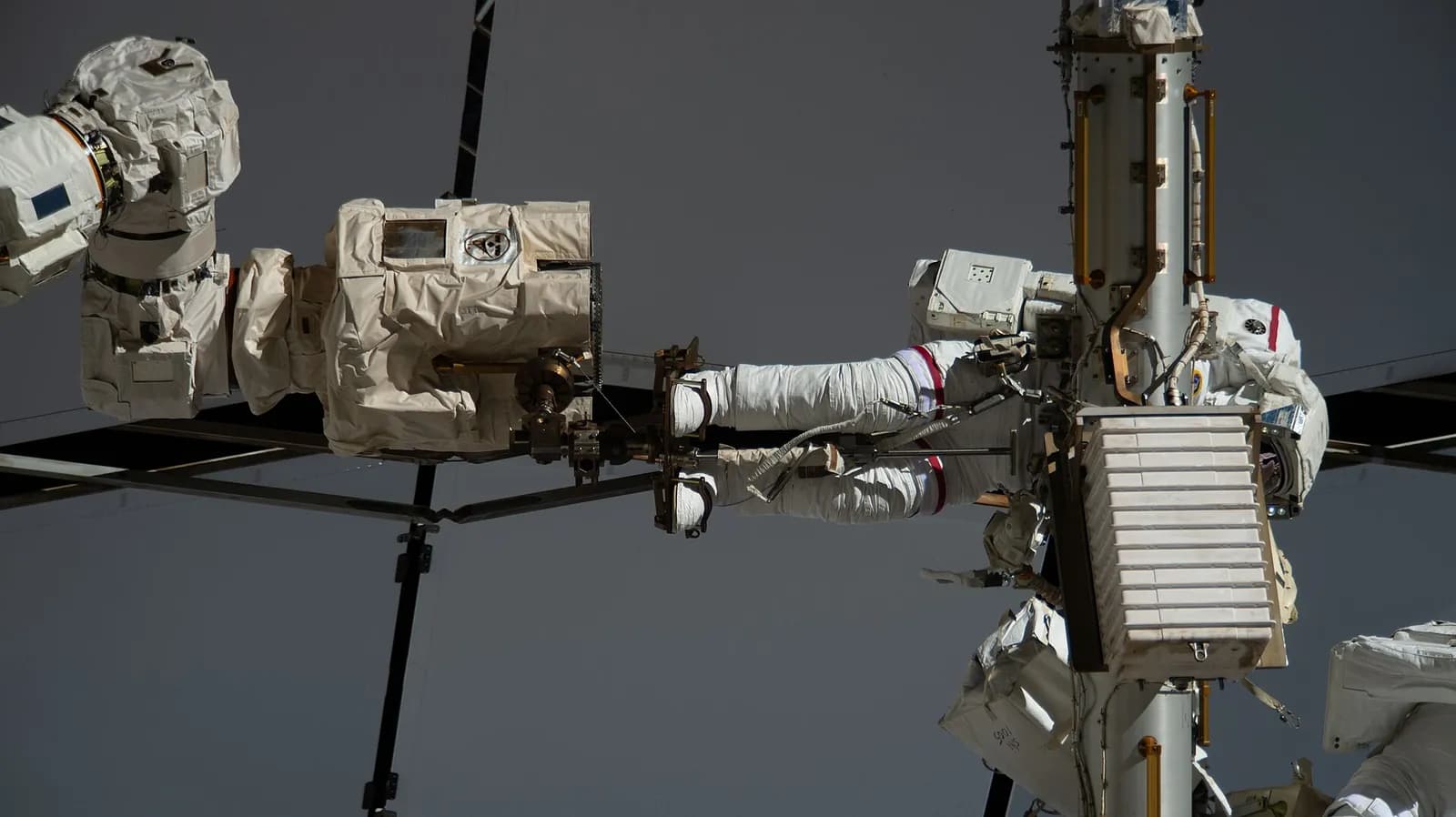 NASA astronaut Anil Menon works outside the International Space Station while attached to the Canadarm2 robotic arm.