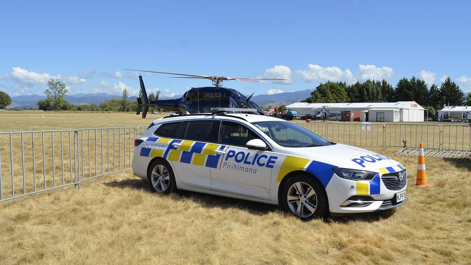 A New Zealand Police car beside an Eagle police helicopter.