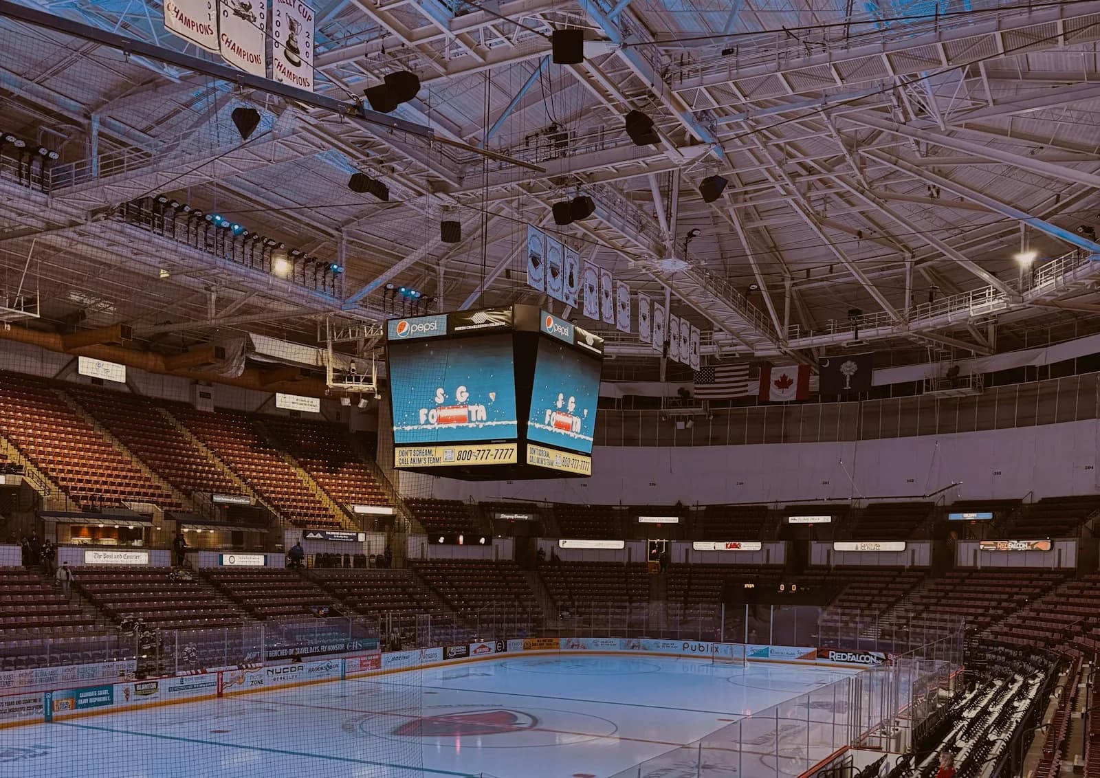An empty ice hockey arena with scoreboard and seating