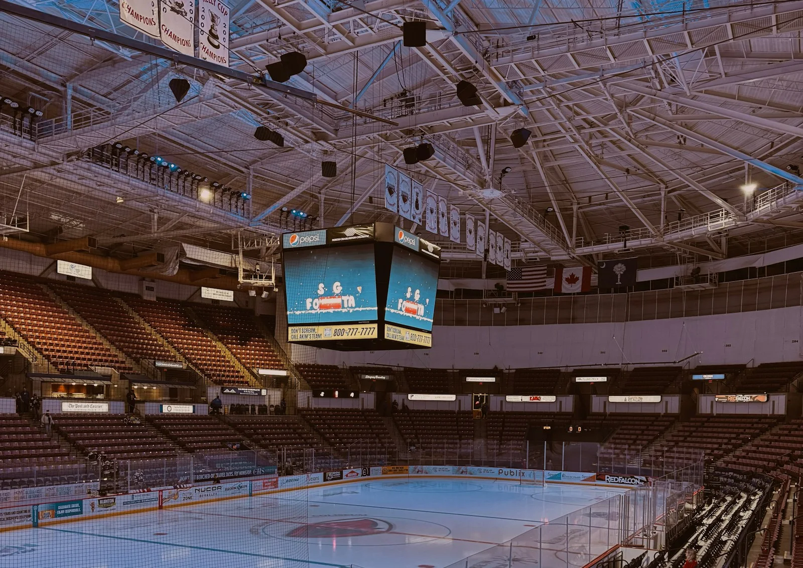 An empty ice hockey arena with scoreboard and seating